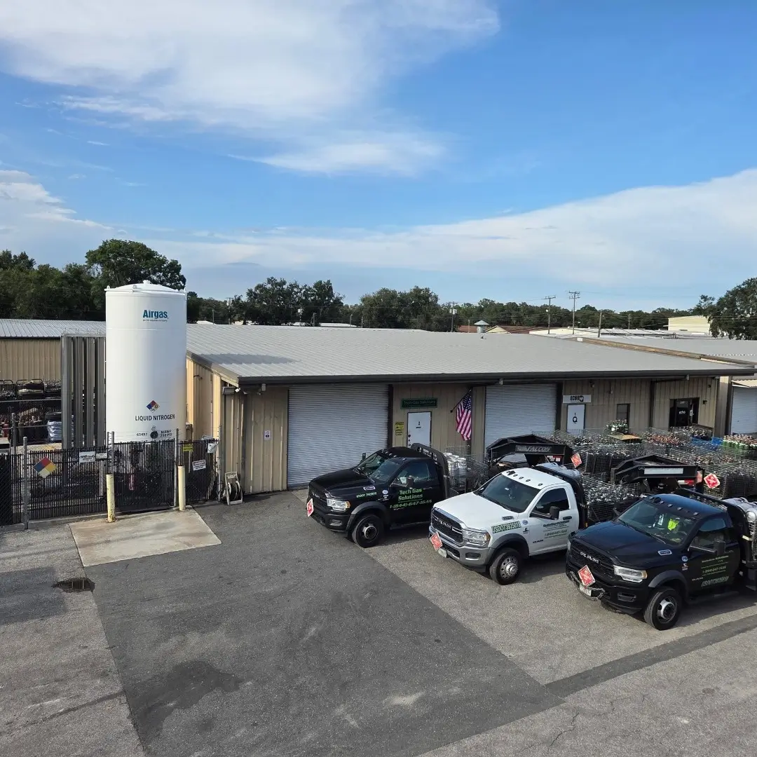 Tech Gas Solutions Lakeland FL facility with delivery trucks, cylinder storage racks, and a liquid nitrogen tank serving the Central Florida region.